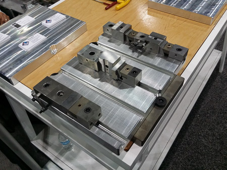 A slotted, serrated pallet, mounted to a base pallet with several variations of Mini Vises